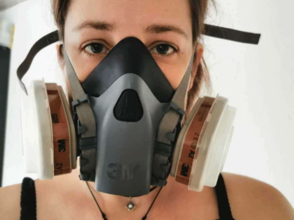 A photo of a woman wearing a respirator mask.